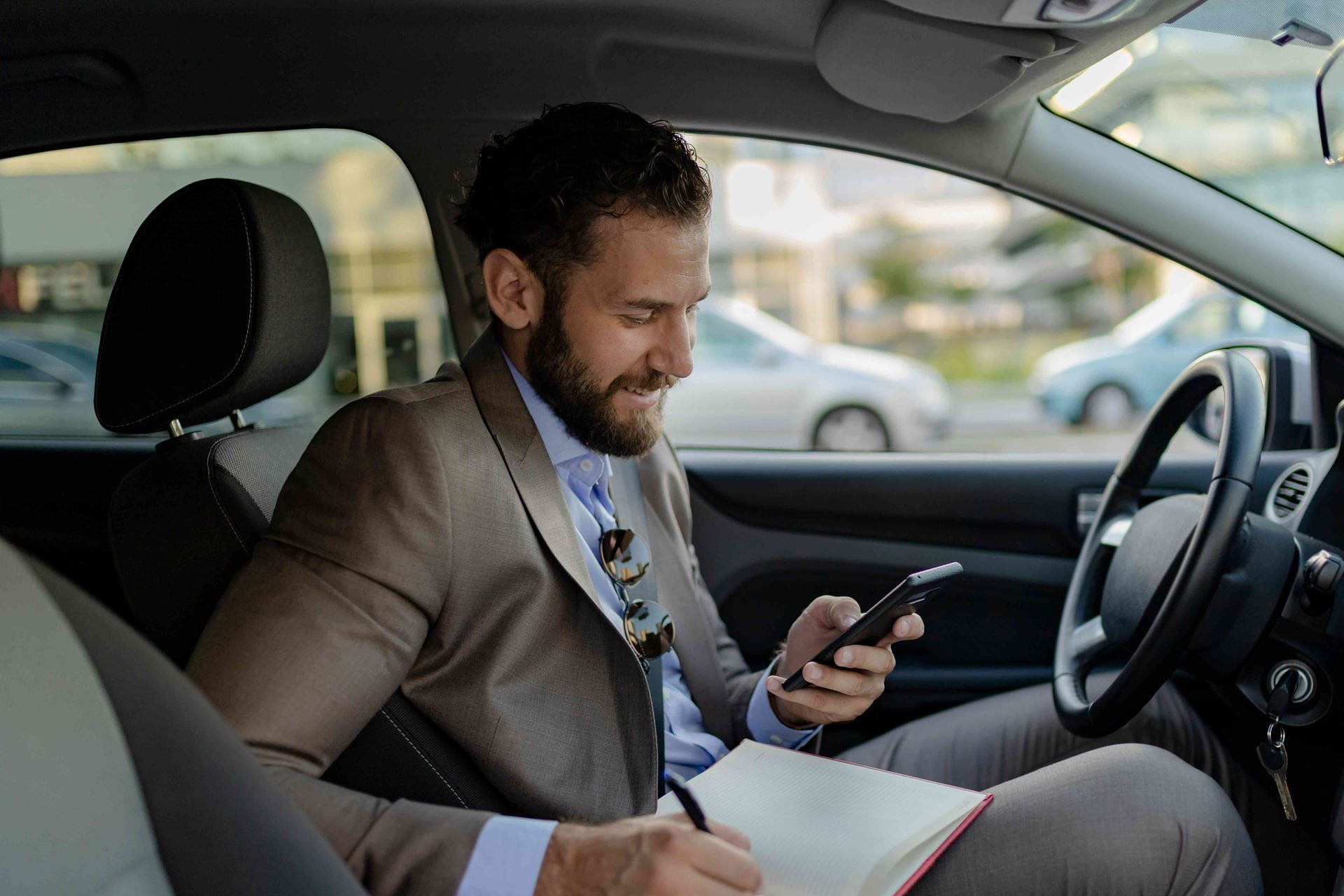 man-writing-in-car