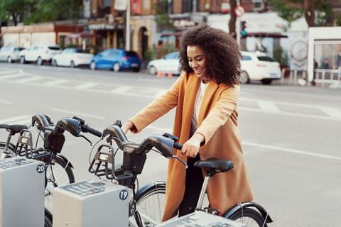 Image d'une femme prenant un vélo sur une borne de vélo public