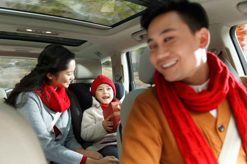 Família feliz dentro de um carro