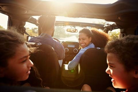 Família feliz dentro de um carro